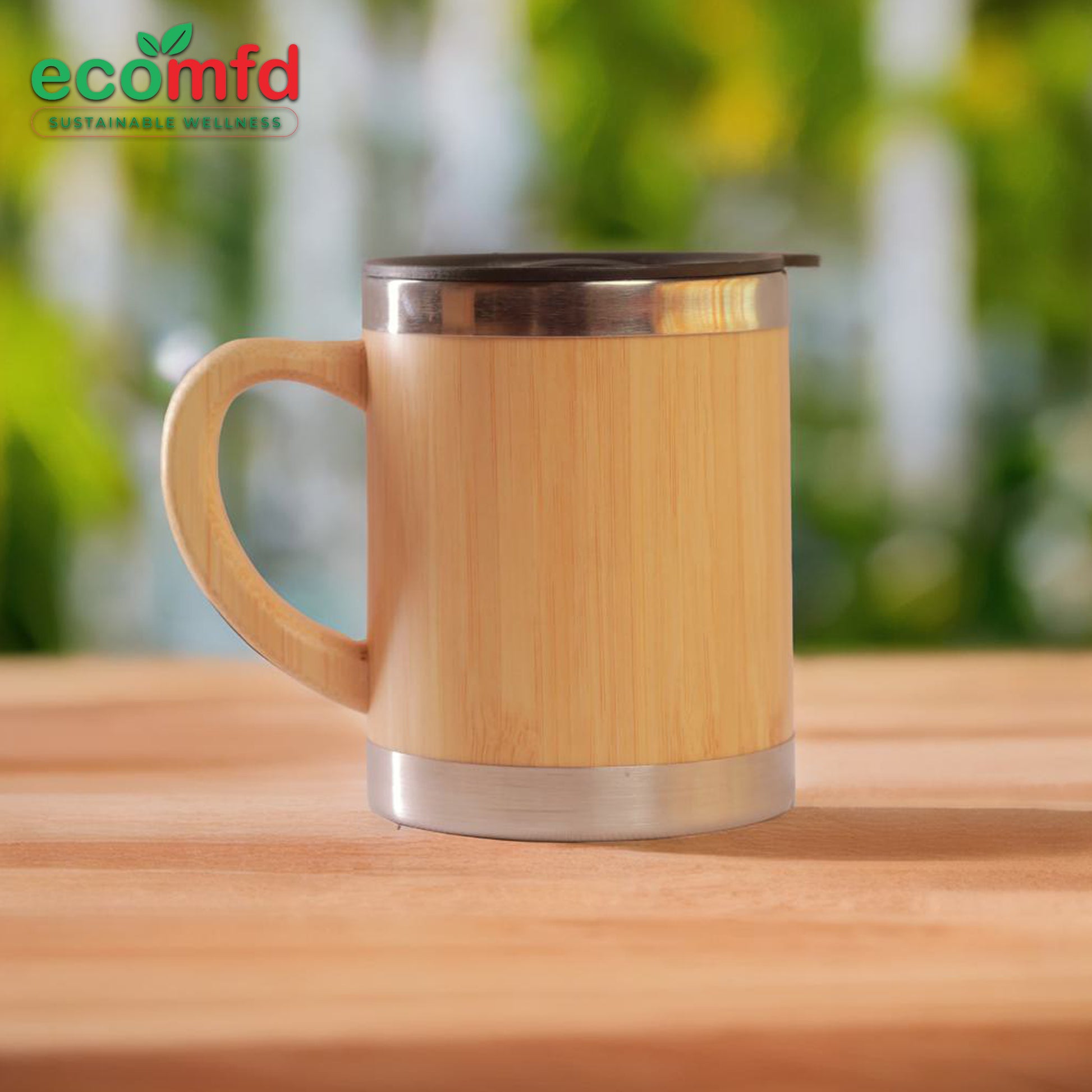Bamboo mug with metal lid on a wooden surface, blurred greenery in the background
