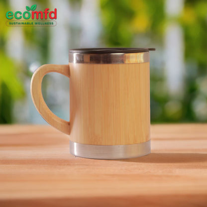 Bamboo mug with metal lid on a wooden surface, blurred greenery in the background